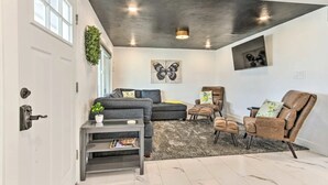 Ein modernes Wohnzimmer mit einem grauen Sofa, einem braunen Ledersessel und einem kleinen Couchtisch.