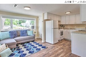 A modern kitchen with white cabinets, a refrigerator, and a stove.