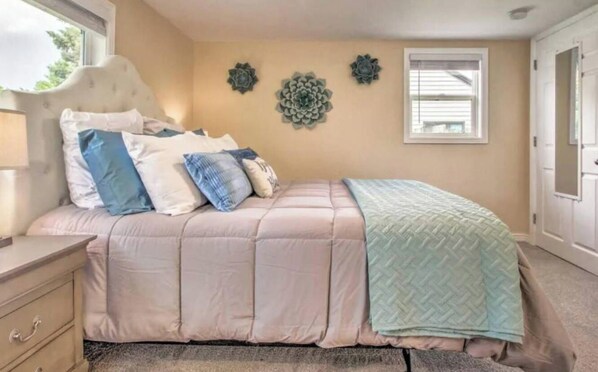 A bedroom with a bed, bedside table, and decorative wall art.