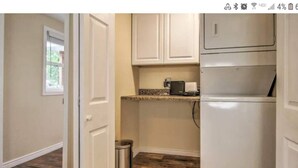 A compact kitchen with white cabinets, a stainless steel trash can, and a countertop with a coffee maker. - Designer Cottage Retreat | Walkable Downtown | W & R (Great Falls)