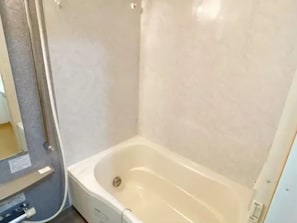 Un baño con bañera, zona de ducha y retrete.