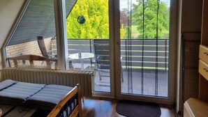 A bedroom with a bed, a window, and a view of a balcony. - Ferienwohnung mit Balkon im Wunderschönen Tecklenburg, Wanderwege (Tecklenburg)