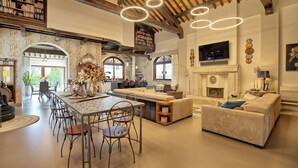 Un amplio salón con una mesa de comedor, sillas, un sofá y una chimenea.