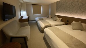 A hotel room with a TV, a desk, two beds, and a patterned wall. - New building Triple room RO | Breakfast inclu / Toon Ehime (Toon)