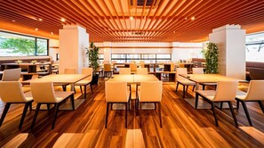 A modern dining area with wooden flooring, multiple tables, and chairs. - New building Triple room RO | Breakfast inclu / Toon Ehime (Toon)