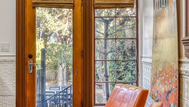 A room with a large window, a door, and a bench.