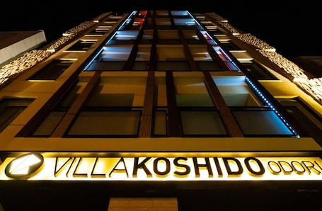 A hotel facade with illuminated signage reading "Villakoshido Odori".