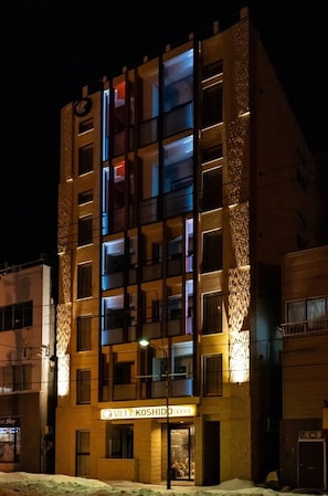 A multi-story building with a sign reading 'VILAKOSHIDO COOPERT'.