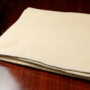 A soft, inviting blanket lies folded on a polished surface.