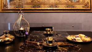 A table with a decorative tray, a candle, and a plate of cookies. - Dubai RC luxury (Reggio Calabria)
