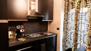 A modern kitchen with a black countertop, stainless steel appliances, and decorative items. - Dubai RC luxury (Reggio Calabria)