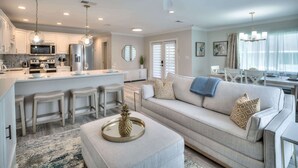 A modern kitchen with white cabinets, stainless steel appliances, and pendant lighting. - Island Gold Steps to the Beach - Heated Pool (Fort Myers Beach)