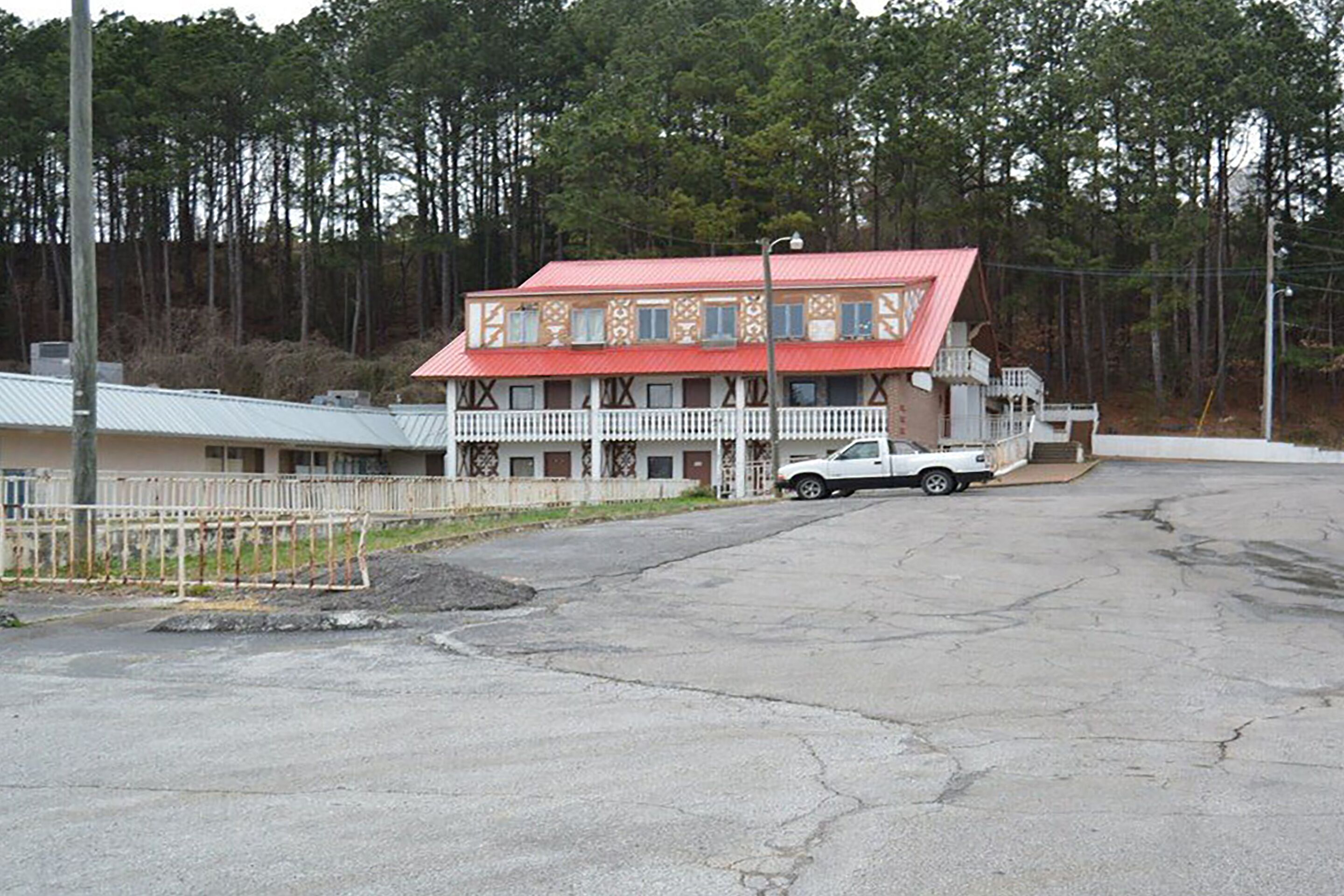 A two-story building with a red roof and white balcony railings.