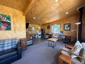 Een gezellig interieur van een chalet, met een eethoek, keuken en zithoek.