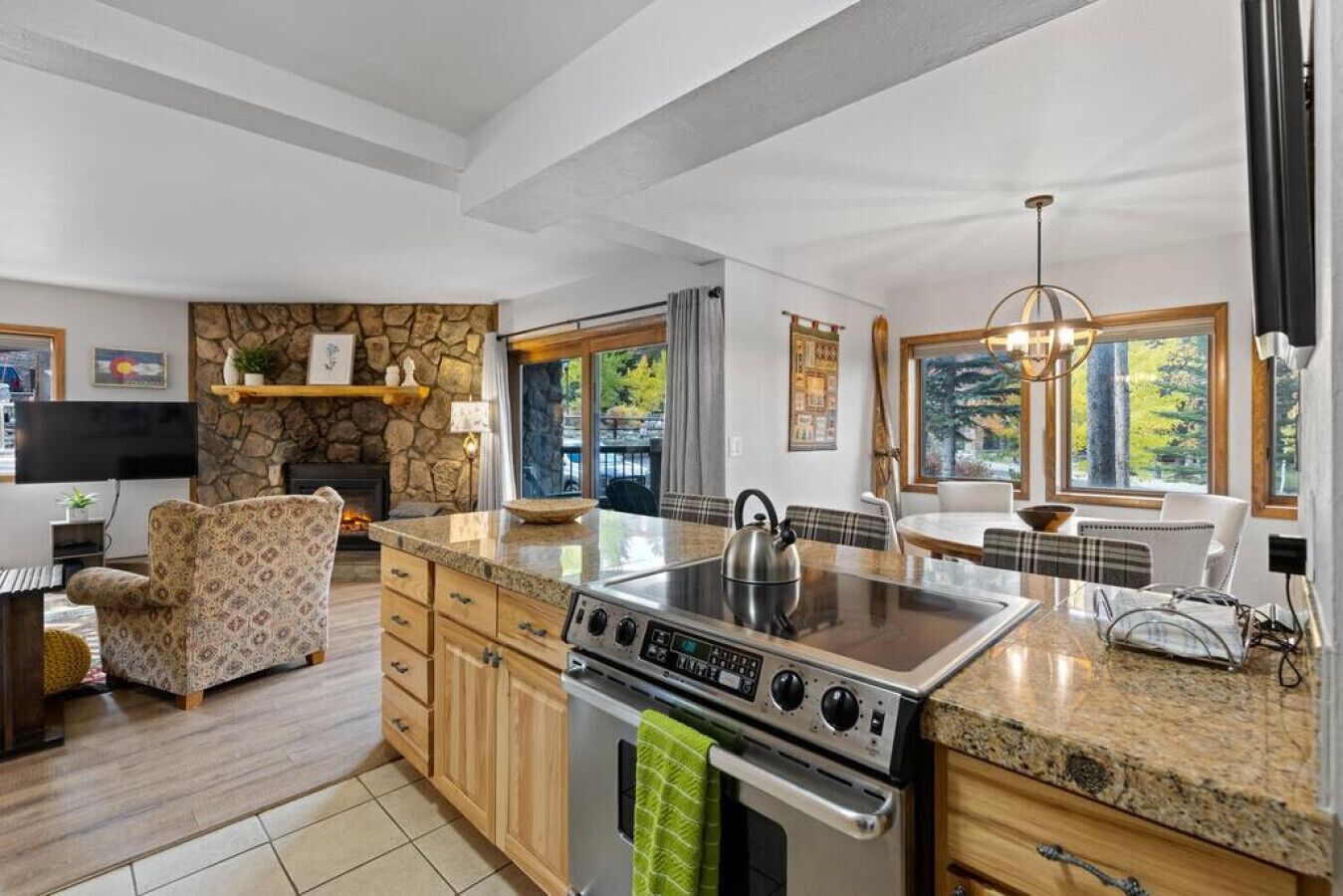 A modern kitchen with granite countertops, a built-in stove, and a stone accent wall.