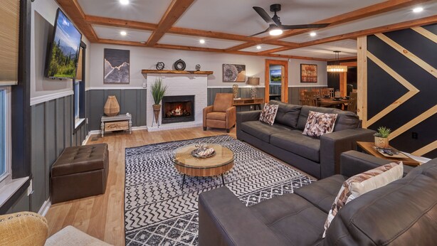 A modern living room with a fireplace, sofas, a coffee table, and a ceiling fan. - ENTERTAINMENT GALORE!NEWLY UPGRADED -GREAT LOCATION, CLOSE TO MAJOR ATTRACTIONS! (Sevierville)