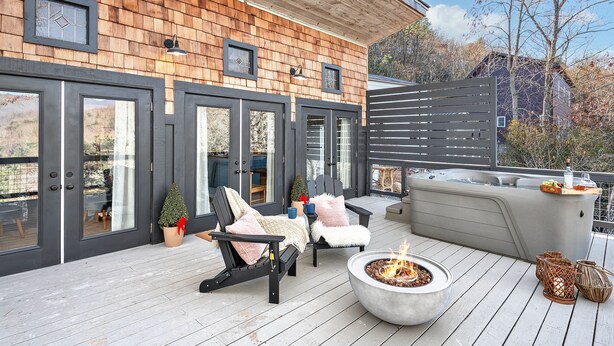 Una terraza con mobiliario exterior, un pozo de fuego y un jacuzzi.