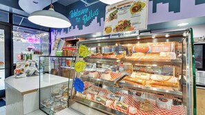 A food display case with various items like chicken, sausage, and bacon. - 3BR Loft Near Convention Center + Breakfast + Pool (Dallas)