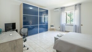 A hotel room with a bed, a desk with a computer, a chair, a wardrobe, and a window with curtains. - Awesome home in Villa S. Lucia (Villa S. Lucia)