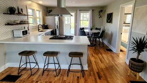 A modern kitchen with a central island, bar stools, a microwave, and a stove. - [C] Private Country Retreat 10 Acres + 4 Min to Lawrence (Lawrence)