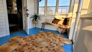 A cozy room with a blue floor, a seating area with cushions, and a potted plant. - [C] Private Country Retreat 10 Acres + 4 Min to Lawrence (Lawrence)