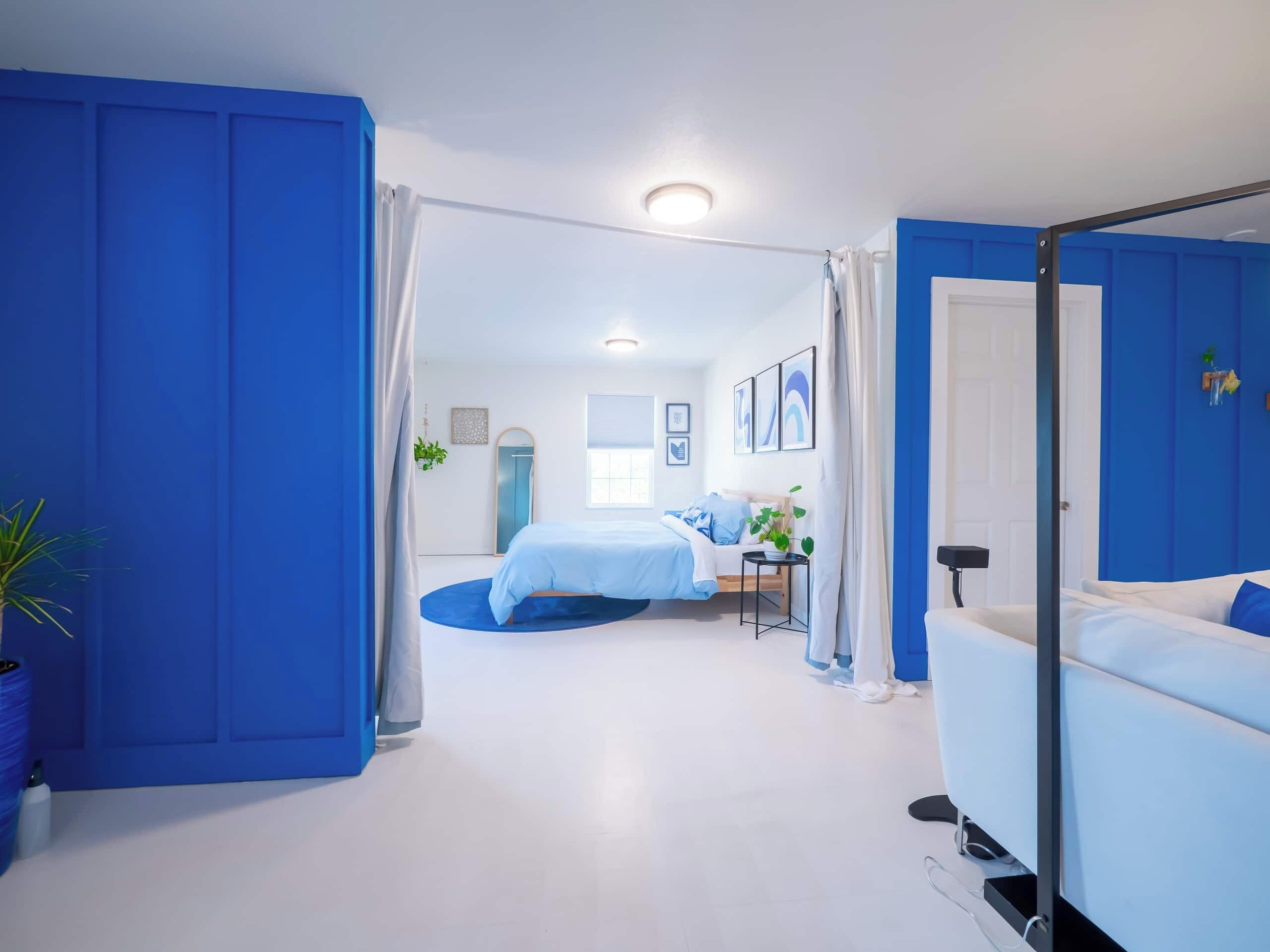 A modern bedroom with a bed, a bedside table, a mirror, and a wardrobe.