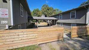 A gated parking area with a covered walkway leading to a building.