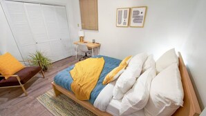 A bedroom with a bed, a desk, a chair, and a wardrobe. - [1] StayAwhile: The Pink Retreat. 2-Min Walk to Mass! (Lawrence)