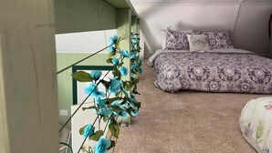 A bedroom with a bed, pillows, and a decorative plant. - The Redbud ~ Cabin Seventeen ~ Lake View ~ Pet Friendly (Royal)