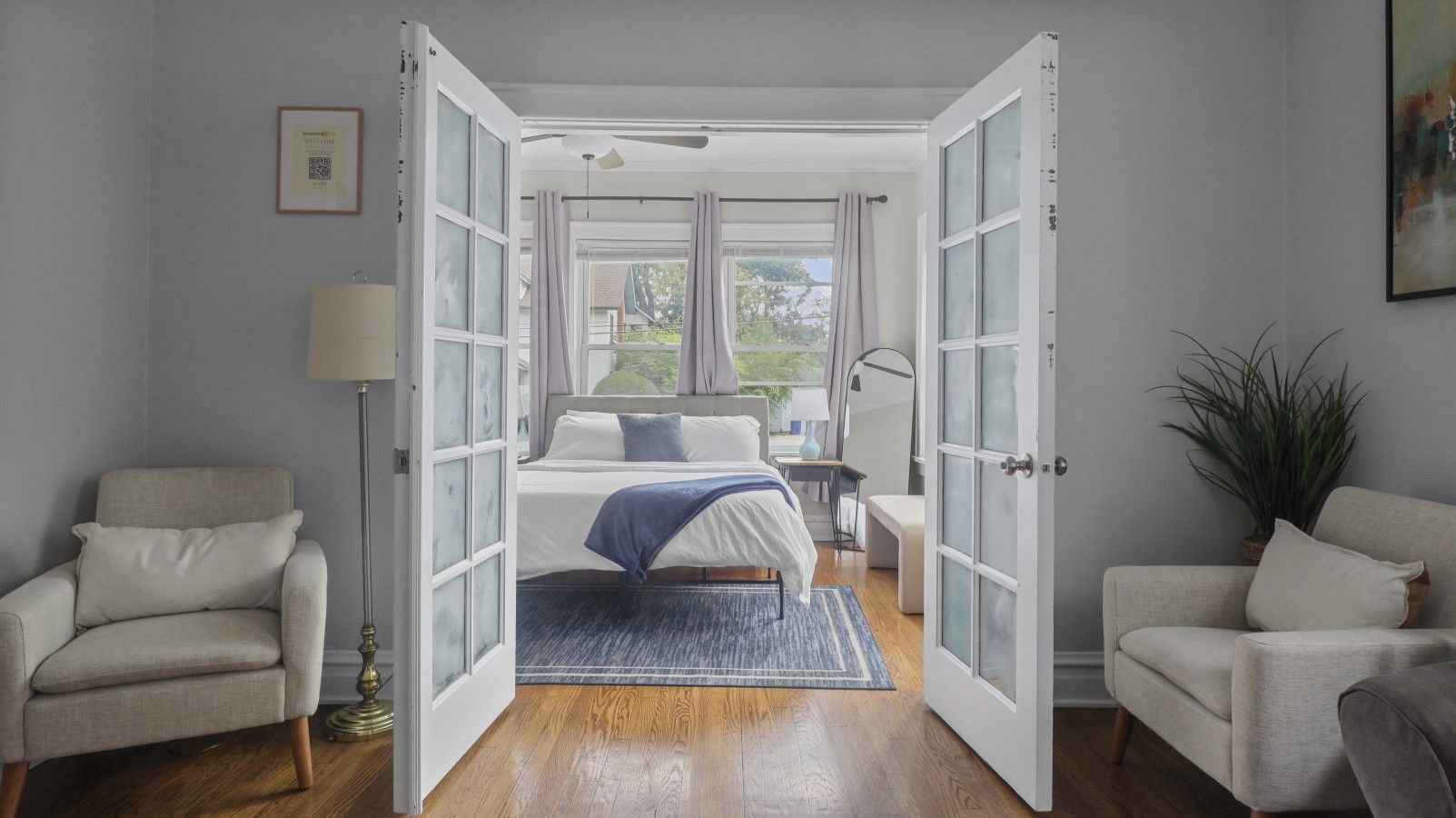 Un dormitorio con una cama, una silla, un escritorio y una planta.