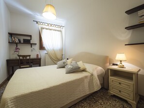 Relax in a spacious room with a large bed, desk, and bookshelf.