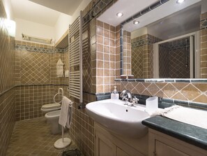 Bathroom features a large sink, mirror, and toilet with a towel nearby.