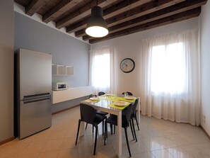 Enjoy meals in this kitchen and dining area, featuring a refrigerator, microwave, and table for four.