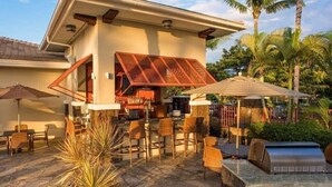 Une maison moderne dotée d’un bar, d’un espace salon extérieur et d’une terrasse en pierre.