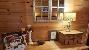 A wooden dresser with a mirror, a lamp, and a framed picture.