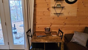 Un interior de madera con una mesa de comedor, sillas, un reloj y un sofá.