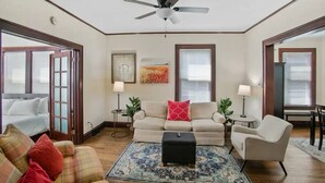 A living room with a sofa, armchairs, a coffee table, and a ceiling fan. - Cozy home perfect for families - Near Naval Base! (Waukegan)