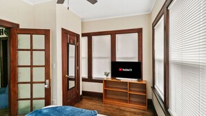 A bedroom with a bed, a TV on a wooden stand, and a ceiling fan. - Cozy home perfect for families - Near Naval Base! (Waukegan)