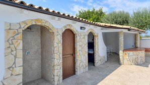 Un bâtiment aux murs de pierre et doté de nombreuses portes donnant accès à des espaces intérieurs.