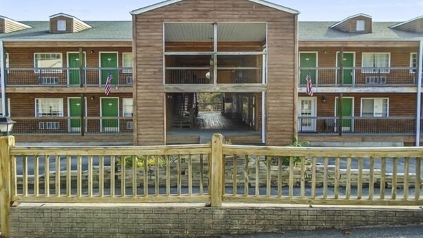 A two-story motel with a central entrance and balconies on each floor. - Standard Double Queen Room (Branson)