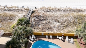 A beach view with a pool area, beach umbrellas, and lounge chairs. - Renovated oceanfront penthouse condo - direct beach access!  (Fort Walton Beach)