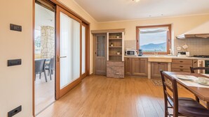 A modern kitchen with wooden cabinets, a stone accent wall, and a view of the outdoors.