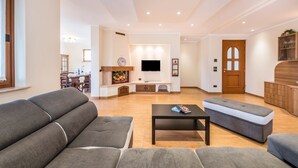 A modern living room with a sofa, ottoman, and a coffee table.