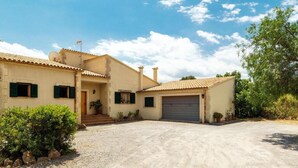 Une maison à deux étages avec un garage, un porche à l’avant et une allée gravillonnée.