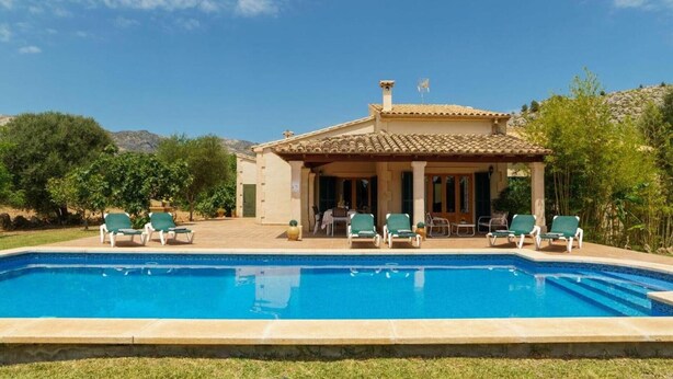 Une villa avec piscine, située au bord de la piscine, dotée d’un espace extérieur aménagé et offrant une vue sur le paysage environnant.