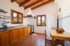 Una cocina con armarios de madera, estufa, fregadero y ventana con vistas.