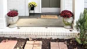 A white brick building with a green door, numbered 1590, and potted plants on either side of the entrance. - Cozy Home 10 minutes from downtown Norcross and 25 minutes from downtown Atlanta (Norcross)