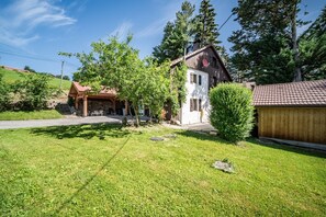 A house with a stone foundation, a wooden porch, and a small garden area. - Chalet 'Authentique En Vallée Verte' with Mountain View, Shared Terrace & Wi-Fi (Bogève)