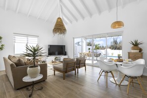 Un salon moderne avec un canapé, une table basse et un coin repas.