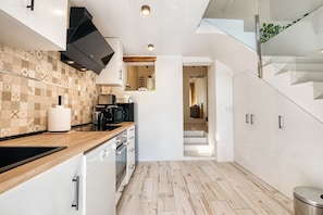 A modern kitchen with a wooden countertop, white cabinets, and a patterned backsplash. - Holiday Home 'Mirasol' with Mountain View, Private Terrace and Wi-Fi (Benitachell)